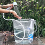Portable electric shower pump drawing water from a bucket outdoors